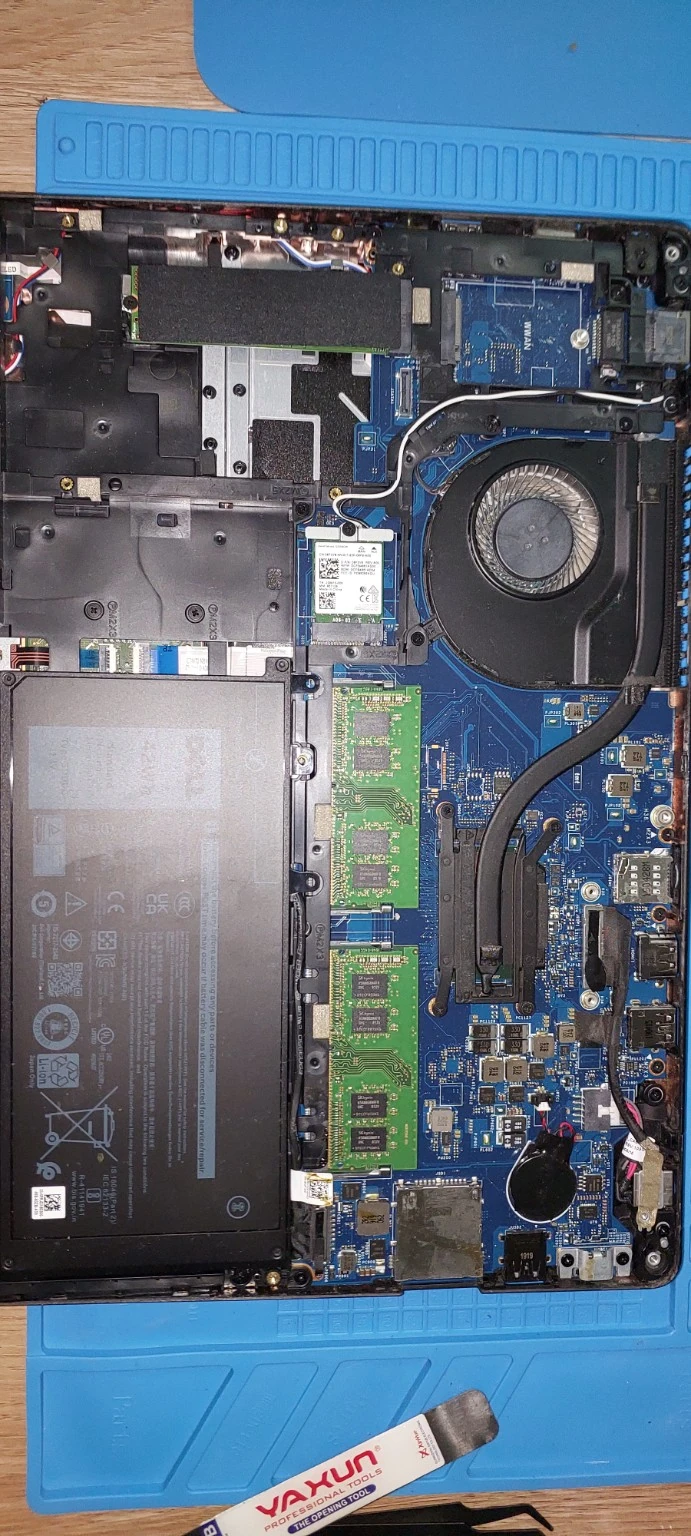Interior de una notebook con la placa, memorias, batería y ventilador visibles