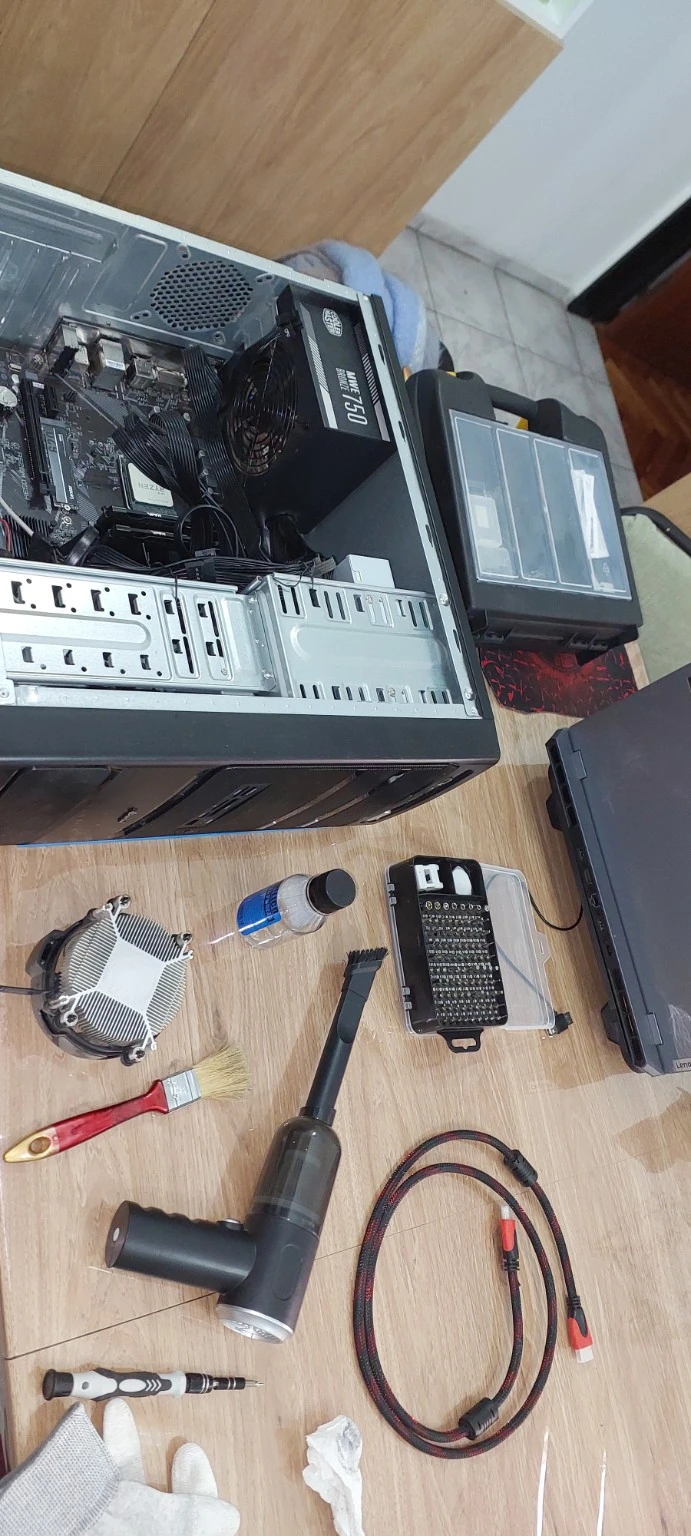 PC de escritorio abierta con el disipador y las herramientas sobre la mesa